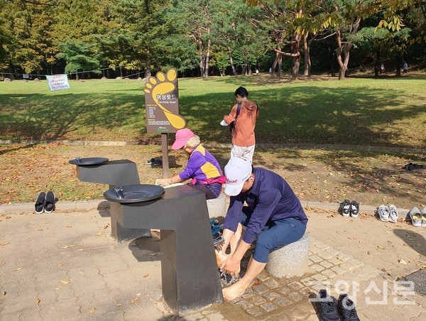 정발산공원 스마트 건강길을 걷고 발을 씻는 시민들.