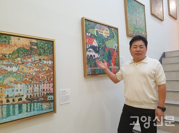 권순상 대표가 1층 계단 입구부터 전시된 작품을 설명하고 있다.