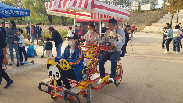   관람객들이 자전거로 축제장을 둘러보고 있다.