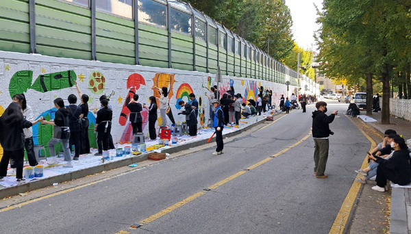 일산1동 주민자치회 위원과 미술학원 학생 및 강사 등이 참여해 일산고교 담장에 벽화를 그리고 있다.