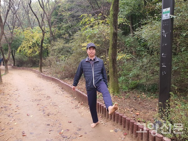 최성연 전 정발산동 동장이 맨발걷기를 하고 있다.