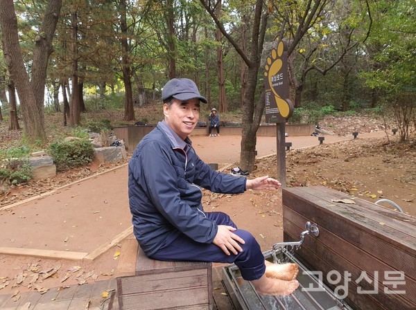 최성연 전 정발산동 동장이 맨발걷기 후 세족장에서 발씻기를 하고 있다.