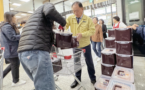  김치를 담근 상자를 나르는 장순복 조합장(오른쪽 노란옷).