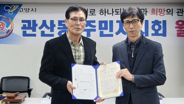 김문식 주민자치회장(왼쪽)에게 김기세 관산동장(오른쪽)이 위촉장을 전달하고 있다.