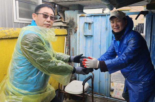 로타리클럽 회원들이 연탄을 나르고 있다.