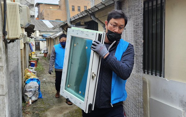 로타리클럽 회원들이 주거환경 개선 공사 중 창호 교체를 하고 있다.