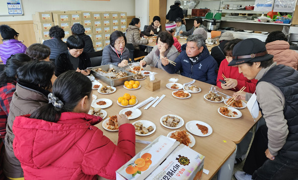 이날 김장김치 담그기에 동참한 주민과 봉사자들이 맛있는 식사를 하고 있다.