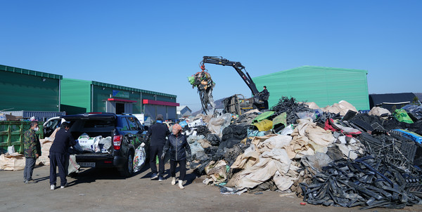농업인들이 가지고 온 폐농자재를 수거 관계자들이 분리와 정리를 하고 있다.
