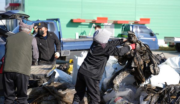 농민들이 농업용 폐자재를 분리하고 있다.