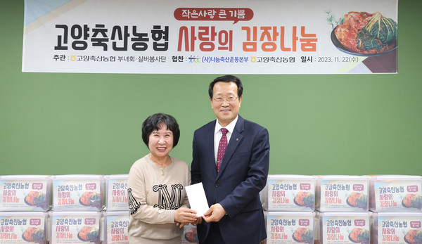 고양축산농협 김옥자 실버봉사단장(왼쪽)이 유완식 조합장에게 김장나눔의 협찬금을 지원했다.