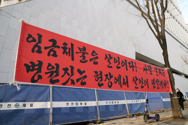 해당 병원 증축공사 현장에 내걸린 현수막. “임금체불은 살인이다. 사람 살리는 병원에서 살인이 웬말이냐”라는 문구가 눈길을 끈다.