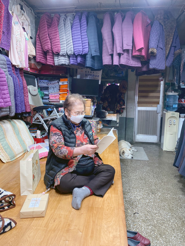 일산동 아카이빙 책자를 인터뷰 대상자인 복근상회 김복례 사장이 읽고 있다.