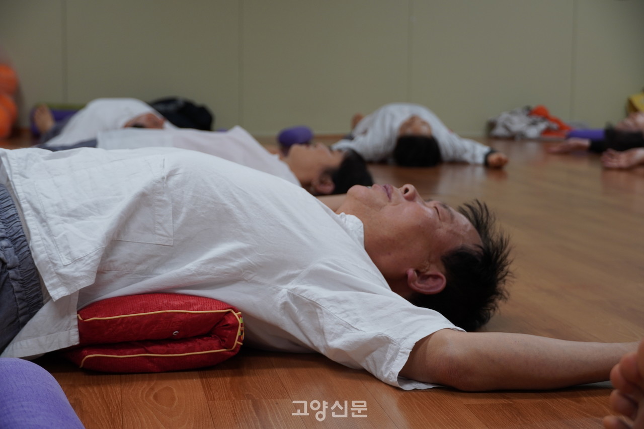 연규문 회원이 방석을 접어 허리에 대고 눕는 '허리 펴기'를 하고 있다.