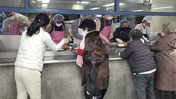 어르신들에게 배식 봉사를 하는 케이마스터즈 직원들.