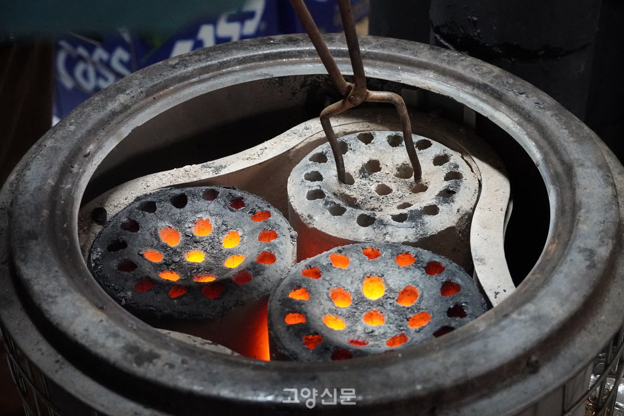 정씨네 집 앞 골목 가게에서도 연탄난로를 사용한다. 연탄난로의 연탄을 교체하는 모습. 