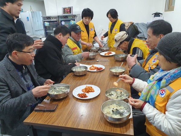 참가자들이 떡국을 끓여 함께 식사를 하고 있다. [사진제공=고양주교동봉사회]