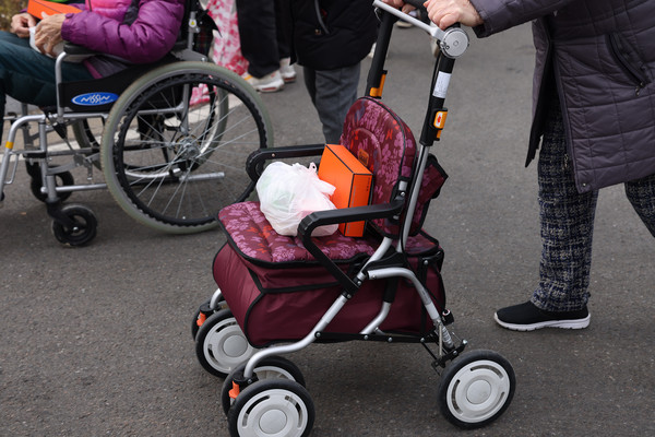 한 어르신이 떡국과 수건을 받고 집으로 향하고 있다.
