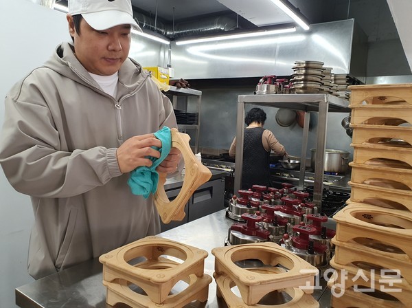 남동생(김종진씨)이 고객상에 나갔던 솥밥 나무거치대를 깔끔하게 닦고 있다.