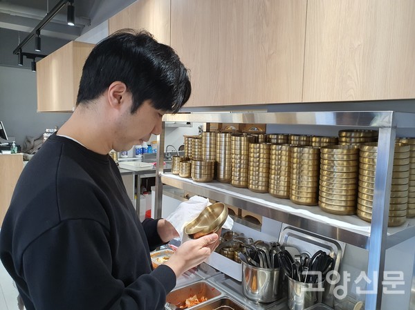 김종범 대표가 맛과 멋을 담기 위해 유기그릇과 느낌이 비슷한 티타늄 식기를 닦고 있다.