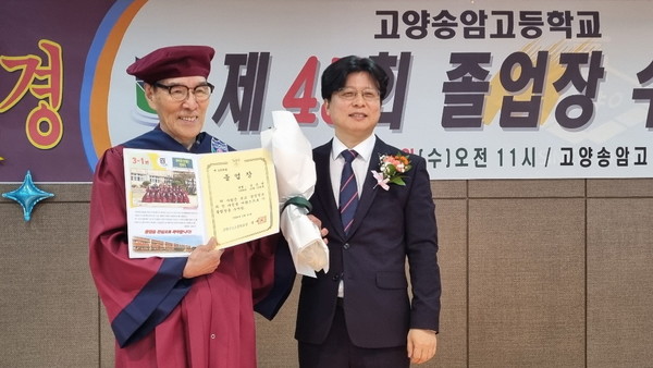 한국 최고령 고교 졸업자라는 기록을 세운 90세 김은성 할아버지가 정재도 교장에게 졸업장을 받고 활짝 웃고 있다.