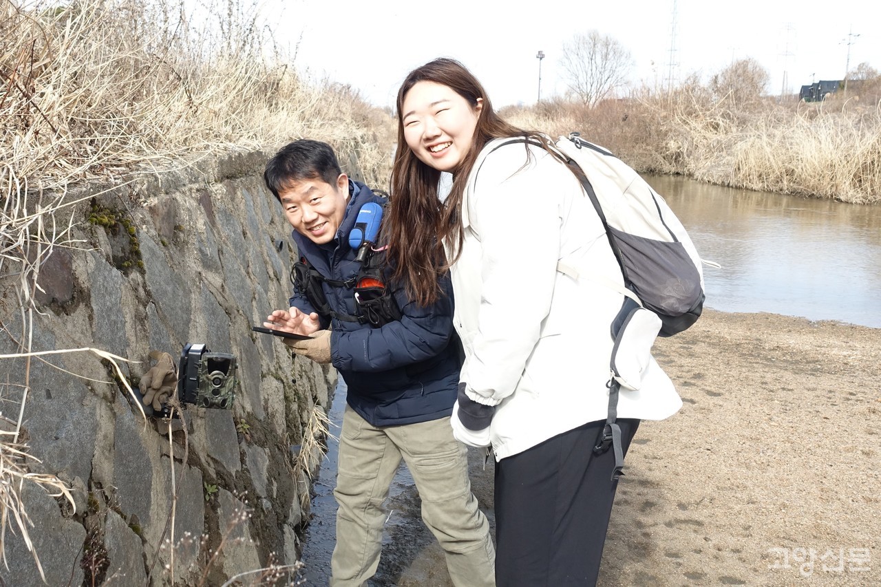 지난달 24일 창릉천에서 무인 카메라를 점검하며 활짝 웃고 있는 이상규(왼쪽), 김지희씨.