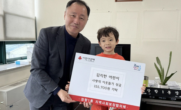 김지한 어린이(오른쪽)가 이웃돕기 사랑의 성금 155,700원을 장항1동에 기탁했다. 