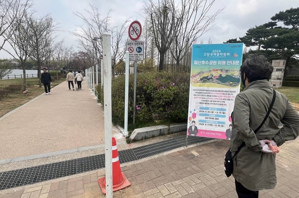 주민들이 호수공원 산책로 제한 안내문을 보고 있다.