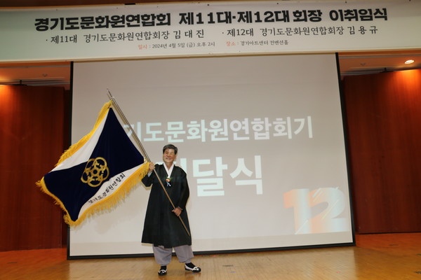 이임 회장에게 전달받은 경기도문화원연합회기를 흔드는 김용규 회장 [사진제공=고양문화원]