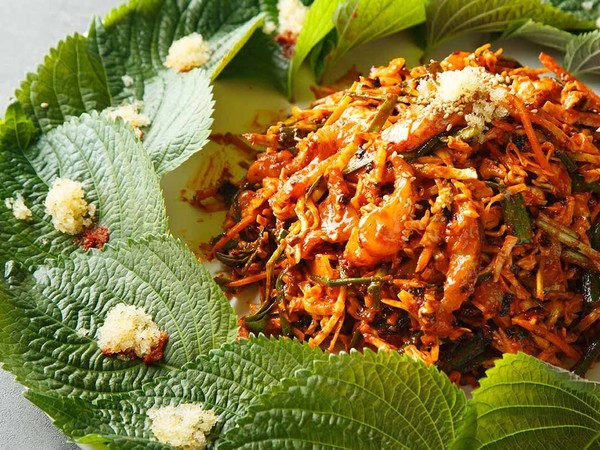 강릉집 대표메뉴인 우럭회무침. 싱싱한 우럭과 채소를 갖가지 천연재료가 들어간 소스로 버무려 가운데에 두고 접시 가장자리에 깻잎을 부채처럼 펼쳐 내온다.