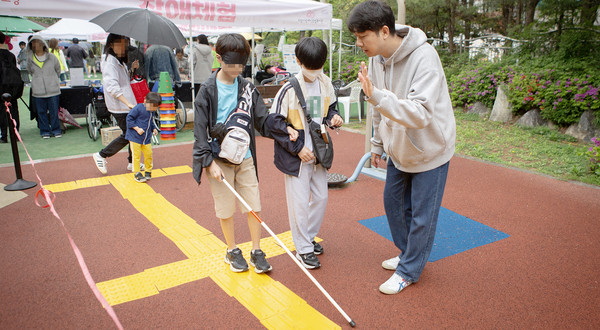 눈을 가리고 장애체험을 해보고 있는 아이들.