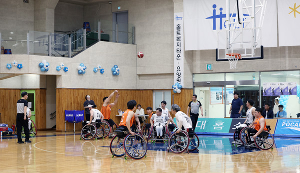 힘차게 골대를 향해 공을 던지는 농구단 선수