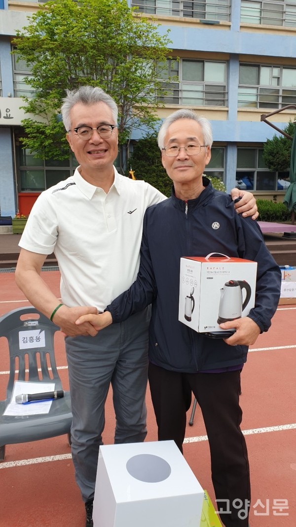 경품추첨에 당첨된 동문에게 상품을 전달하고 있는 정성현 덕양중학교 총동문회장(사진 왼쪽)