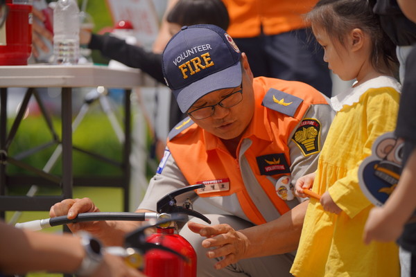 어린이에게 소화기 작동법을 알려주고 있는 소방관. [사진제공=고양시]