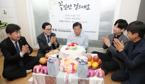 어르신댁을 찾아가 경로잔치 상에서 어버이은혜를 부르는 관계자들.