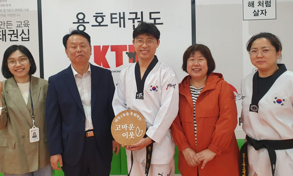 마두1동 지역사회보장협의체가 용호태권도에 '고마운 이웃' 현판을 전달하고 있다.