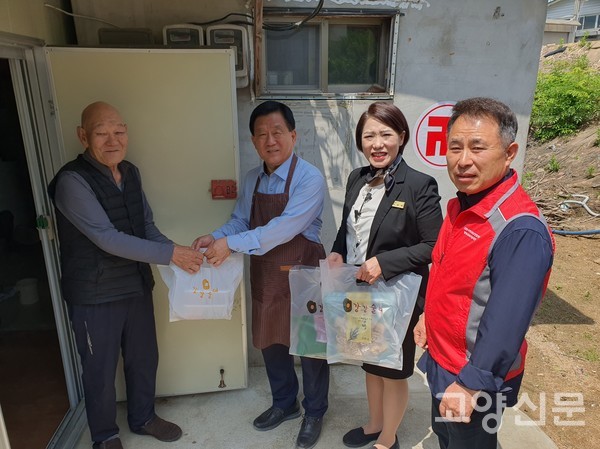 문병원 점장, 조성애 팀장, 정승채 위원이 한 어르신에게 반찬을 전달하고 있다.