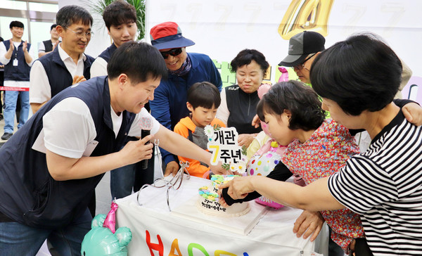 개관 7주년을 기념해 지역주민과 함께 케이크를 자르며 축하하고 있다.