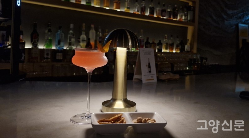 보드카를 베이스로 크랜베리 주스의 상큼한 맛과 오렌지의 풍미를 느낄 수 있는 ‘코스모폴리탄’ 칵테일. 옅은 주황색의 아름다움으로 뉴욕에서 큰 인기를 끌었던 칵테일이다.