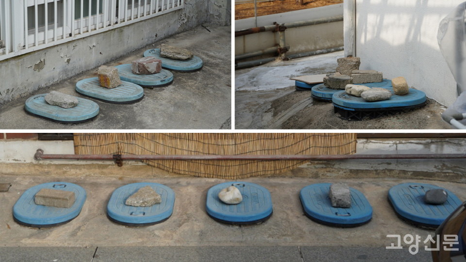 계량기 뚜껑을 돌덩이로 눌러놓은 모습.