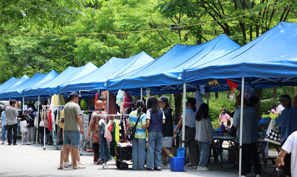  식사동 위시티 자이1단지 아나바다장터에 나온 주민들이 여기저기를 둘러보며 행사를 즐기고 있다.