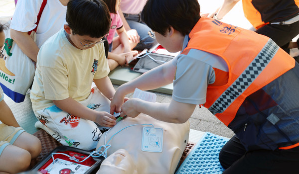 일산동구 소방서의 협조로 응급시 조치요령에 대한 체험을 한 어린이가 하고 있다.