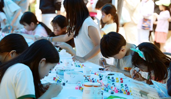 페이스 페인팅과 키링 제작 등의 체험활동을 하는 어린이들.