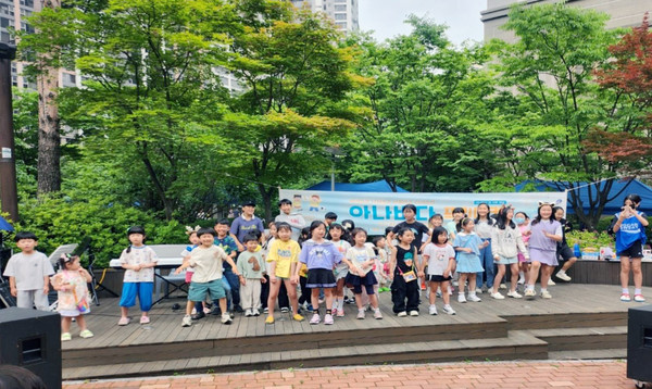   어린이들이 무대에 올라 합창을 하고 있다.