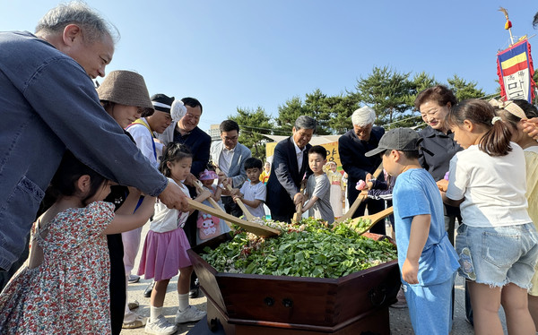 김용규 고양문화원장과 외빈, 어린이들이 고양오월단오제 행사에서 일산열무 비빔밥을 비비고 있다.