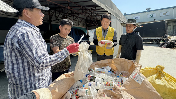 농업경영인 송포지구회 회원, 관계자들과 재활용 플라스틱병에 대해 이야기하는 심은보 조합장(오른쪽 두 번째).