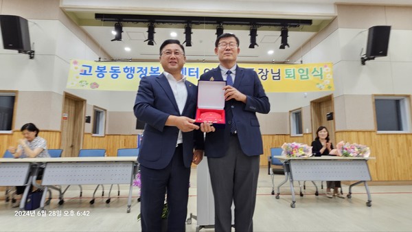 우상훈 벽제농협 조합장(왼쪽)이 이기문 동장에게 공로패를 전달했다.