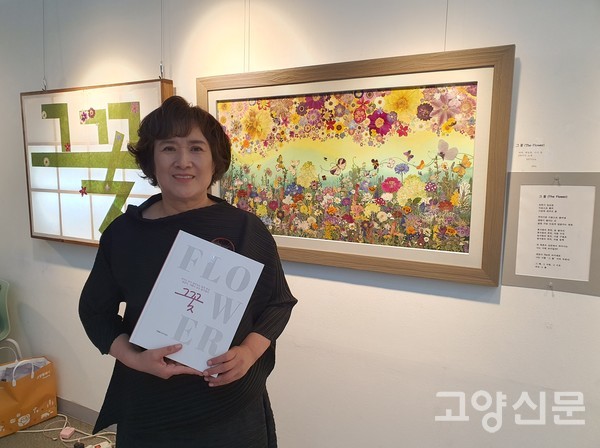 이영애 전 농업기술센터 도시농업과장. 100가지 소재가 들어간 압화작품 앞에서 그가 출간한 '그 꽃' 책을 보여주고 있다