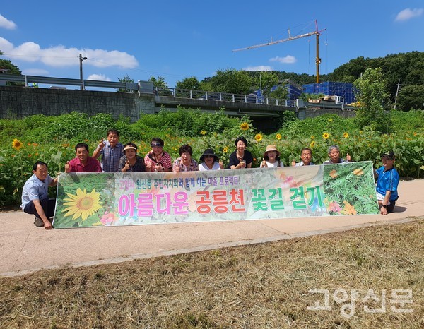 원신동 주민자치위원들이 꽃길 조성 현수막을 부착했다.