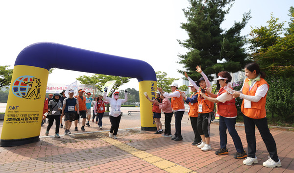 ㎞2024 헬로썸머 걷기 행사에서 5km 코스를 걷고 들어오는 참가자들에게 환호하는 걷기연맹 관계자들.
