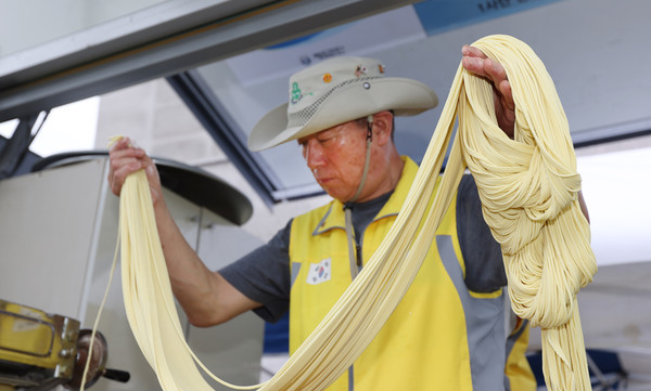 이수영 단장이 즉석으로 반죽에서 면을 뽑고 있다.